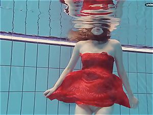 red dressed teenage swimming with her eyes opened